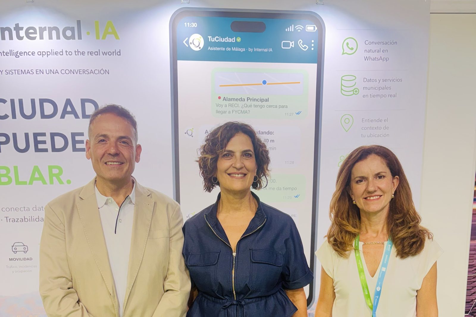 Francisco Orellana, Trinidad Hernández y Gema Casquero ante el rótulo del stand de Internal·IA