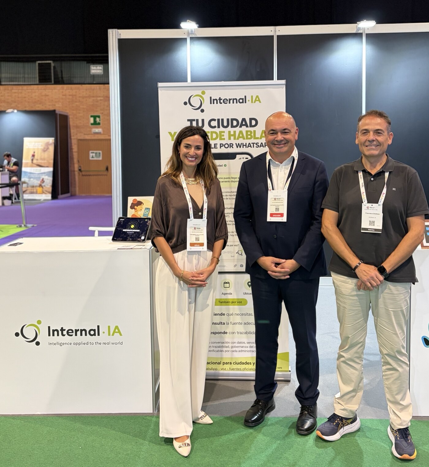 Susana García, Anthony Bermúdez and Francisco Orellana at the Internal·IA stand, in front of the sign “Your city can now speak”